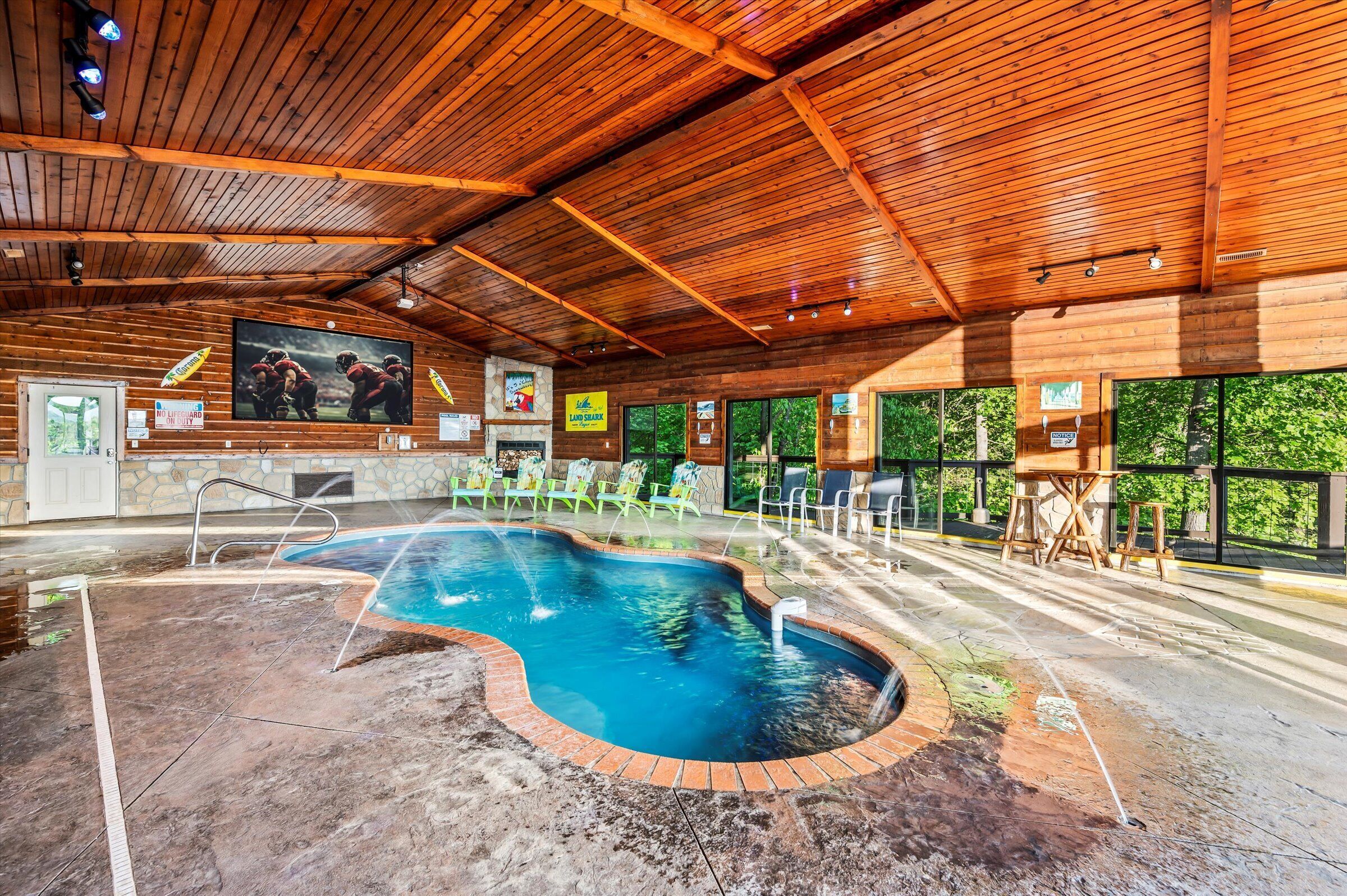 A wooden interior with a pool, seating, and large windows.