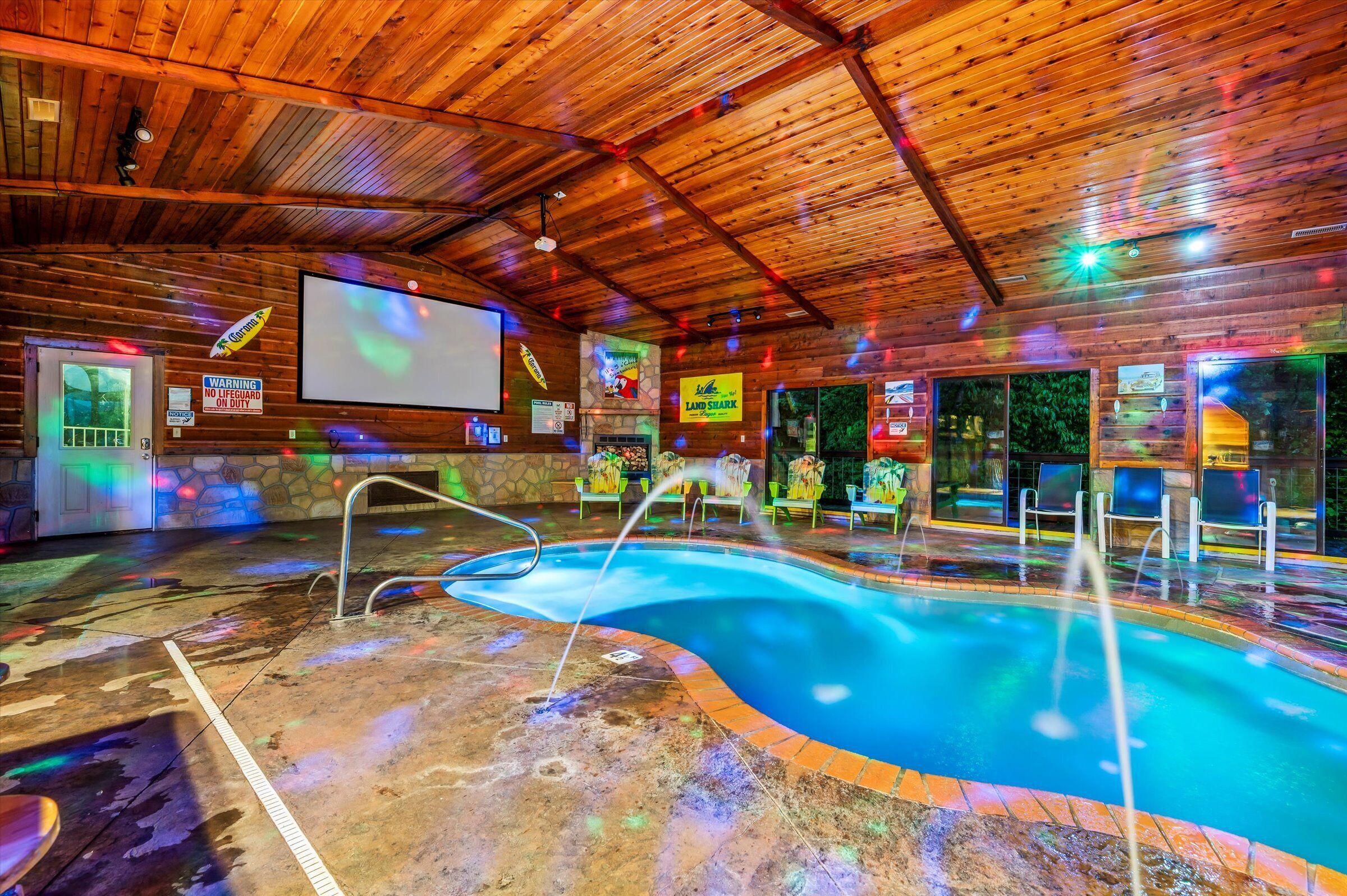 Una piscina interior con techo de madera, una pantalla de proyector y un cartel que dice 'Land Shark'.