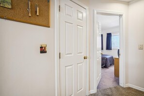 Enter a serene bedroom with a comfortable bed, nightstand, and window with curtains.