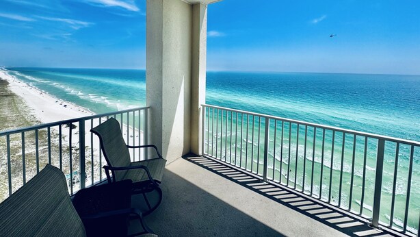 Ein Balkon mit Blick auf den Ozean und den Strand.