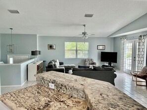 A living room with a sofa, a TV, a ceiling fan, and a window with blinds. - 266 S. Harbor - Anna Maria Island- Private home 3 Bedroom/ 2 Bath , maximum occupancy of 6 people. (Holmes Beach)