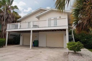 A two-story house with a balcony, two attached garages, and a covered driveway. - 266 S. Harbor - Anna Maria Island- Private home 3 Bedroom/ 2 Bath , maximum occupancy of 6 people. (Holmes Beach)