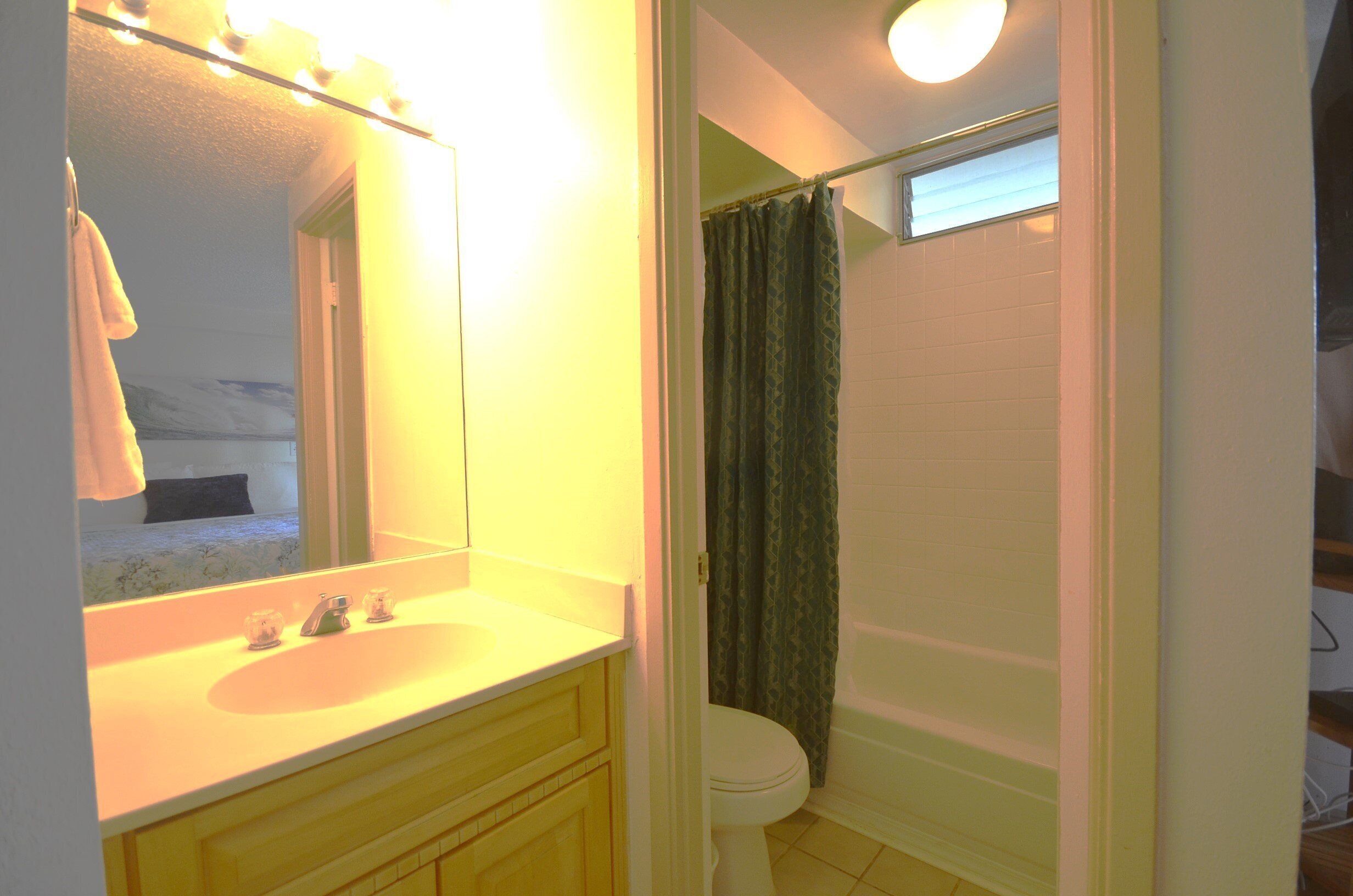 A bathroom with a sink, mirror, and toilet.