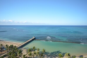A coastal beach with clear turquoise waters, a pier, and palm trees. - Kuhio Village 810A KING Studio, Waikiki Ocean View! (Honolulu)
