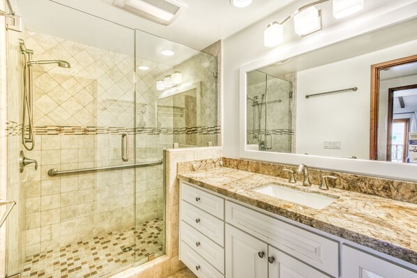 A modern bathroom with a glass-enclosed shower, a large vanity with a sink, and a mirror above the vanity. - H412: Beautiful 2Bd Villa, 1462 SQ FT., Fireplace, Nice Ocean Views, Golf Cart (Avalon)