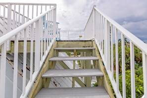 A wooden staircase with white railings leading to a balcony.