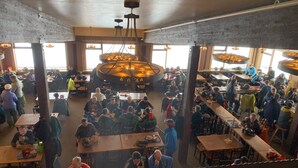 A crowded indoor dining area with high ceilings and exposed brick walls. - 2 story 3 bedroom Ski condo on Hailey’s run at Whitefish Mountain Resort.  (Whitefish)