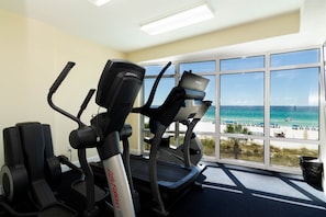 A gym with treadmills and exercise equipment, large windows with a view of the beach and ocean. - Beachfront, Free Beach service, Master on Gulf-Pcb (Panama City Beach Ocean Villa Condominiums)