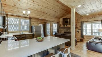 Una cocina amplia con una isla grande, techo de madera y electrodomésticos modernos.