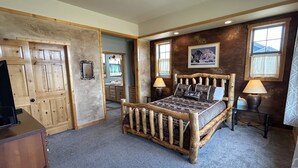 Un dormitorio con una cama de madera, un escritorio, una silla y un aparador.