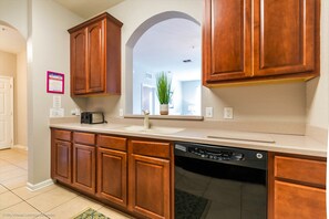 Enjoy cooking in this well-equipped kitchen with a dishwasher and large window offering a view of the interior space.
