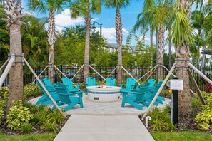 Relax in a tranquil outdoor space surrounded by lush greenery and a fire pit.