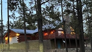 A log cabin with a balcony and a stone wall. - Hillside Rustic Retreat (Greer)