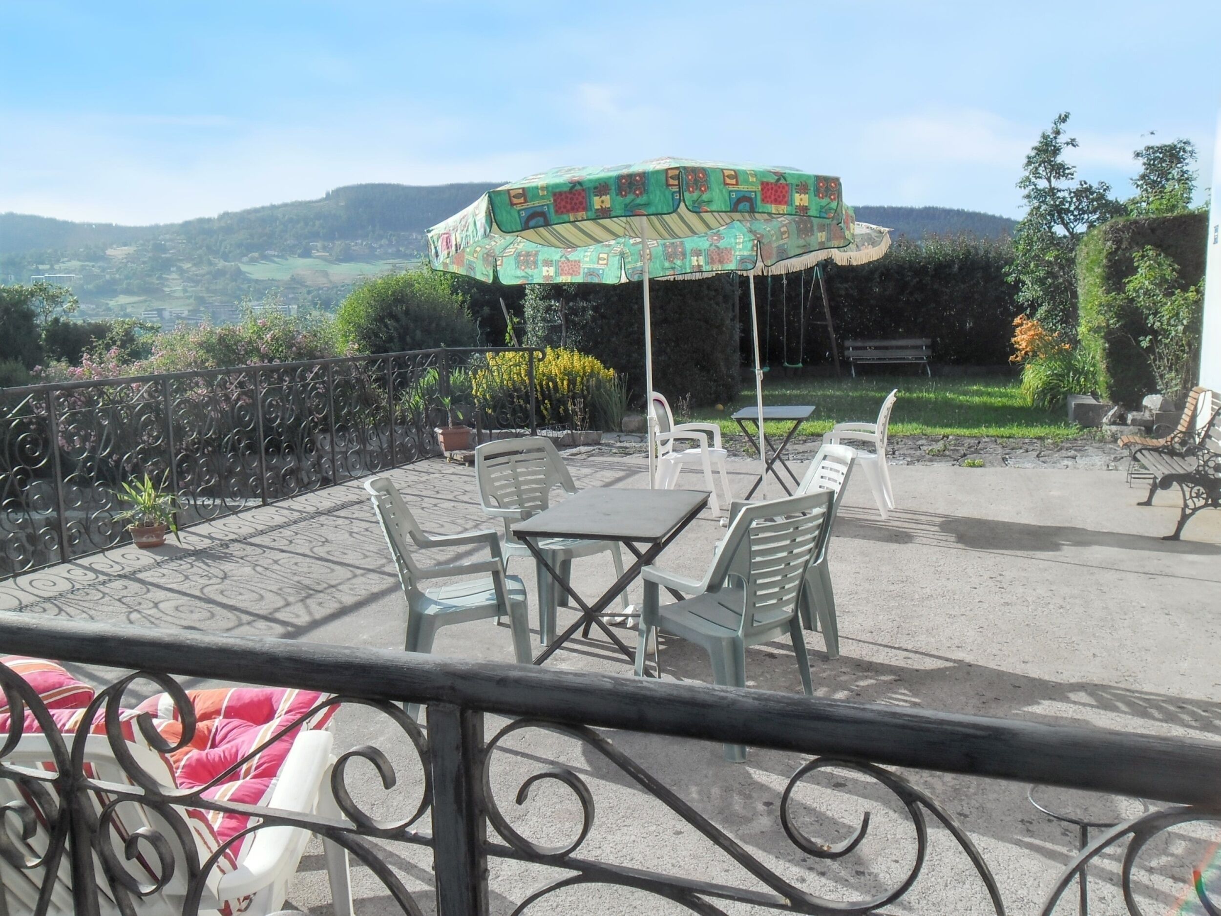 Un patio con mobili da esterno, un ombrellone decorativo e vista sulla campagna.