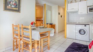 A compact living space with a dining area, a kitchenette, and a washing machine. - T2 cabin 6 people in Luz, quiet, parking, pets allowed (Luz-Saint-Sauveur)