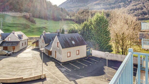 A parking area with several buildings, a mountain backdrop, and a clear sky. - T2 cabin 6 people in Luz, quiet, parking, pets allowed (Luz-Saint-Sauveur)