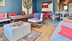 A modern living room with a sofa, a coffee table, a bookshelf, and a dining area. - Tignes, 6 pers, 55m², balcony, parking included (Tignes)