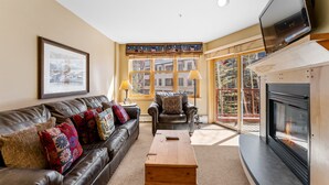 A living room with a fireplace, leather sofas, and a television. - In the Heart of River Run for Easy Access Walk to Shops, Dining & Gondola! (Keystone)