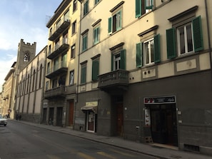 Une vue de rue dâun immeuble dotĂ© dâune tour, de balcons et dâun restaurant appelĂ© « Mala Gastronoma Pizzeria Paniniera ».