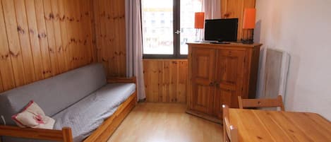 A wooden interior with a sofa, a table, and a cabinet.