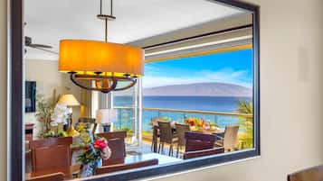 Dining area with classic wood finishes and ocean view through the sliding glass doors.