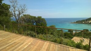 Um deck de madeira com vista para o mar e edifícios à beira-mar.