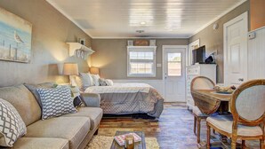 Une chambre confortable avec un lit, un canapé et un coin repas avec des chaises.
