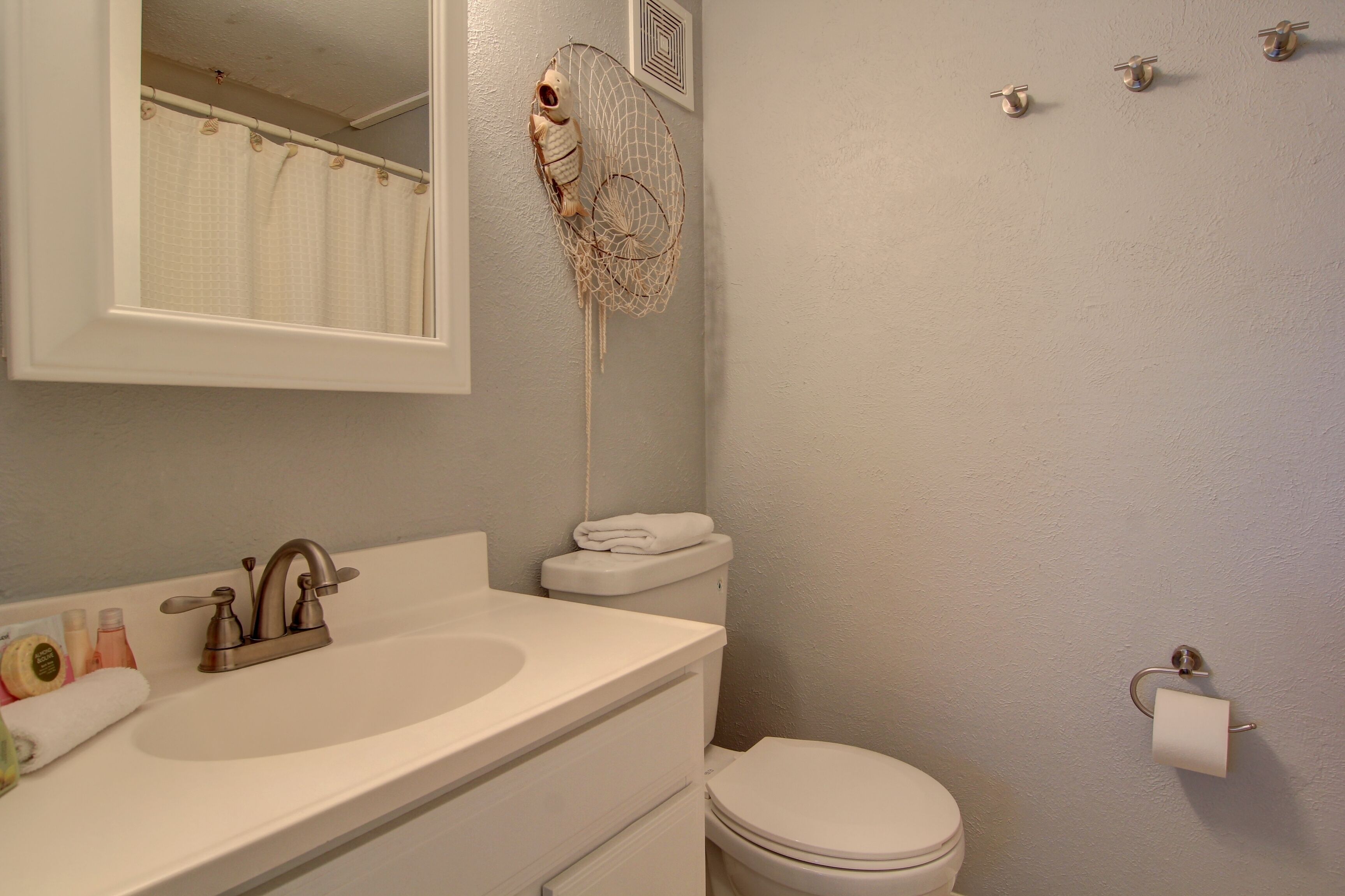 A bathroom with a sink, toilet, and a towel rack.