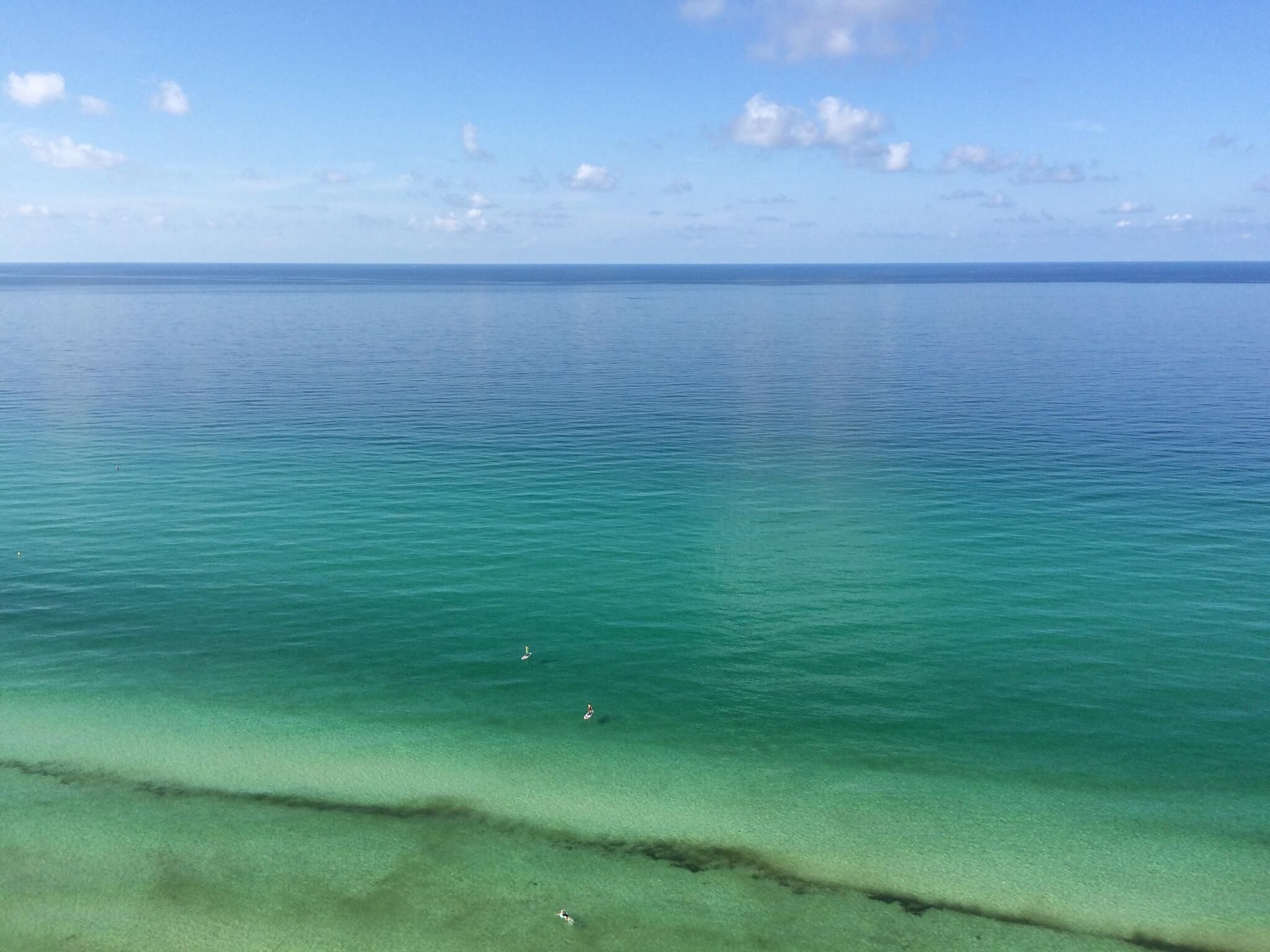 A clear view of a calm sea with a visible shoreline.