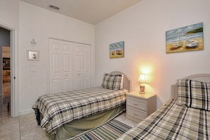 A bedroom with two beds, a nightstand, a lamp, and a door. - 3BR Disney-Area Pool Home | 2 King Beds | BBQ Grill | Dog Friendly (Davenport)