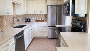 A modern kitchen with white cabinetry, stainless steel appliances, a microwave, and a toaster. - Rio Verde Townhouse overlooking the golf course. (Rio Verde)