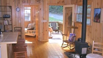 Cozy cabin interior with a dining area, comfortable seating, and a fireplace.