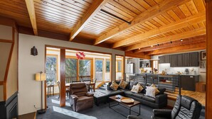 A spacious living area with a large sofa, leather chairs, and a coffee table. A kitchen is visible in the background with modern appliances. - Keystone Townhome Close to Shuttle for Lifts & Short Walk to Lakeside Village (Keystone)