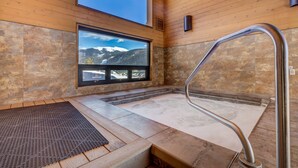 A spa area with a stone floor, a wooden bench, a window with a mountain view, and a metal handrail. - Keystone Townhome Close to Shuttle for Lifts & Short Walk to Lakeside Village (Keystone)