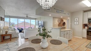 Amplia sala de estar con mesa de comedor, sofás y un ventanal que ofrece vistas al exterior.