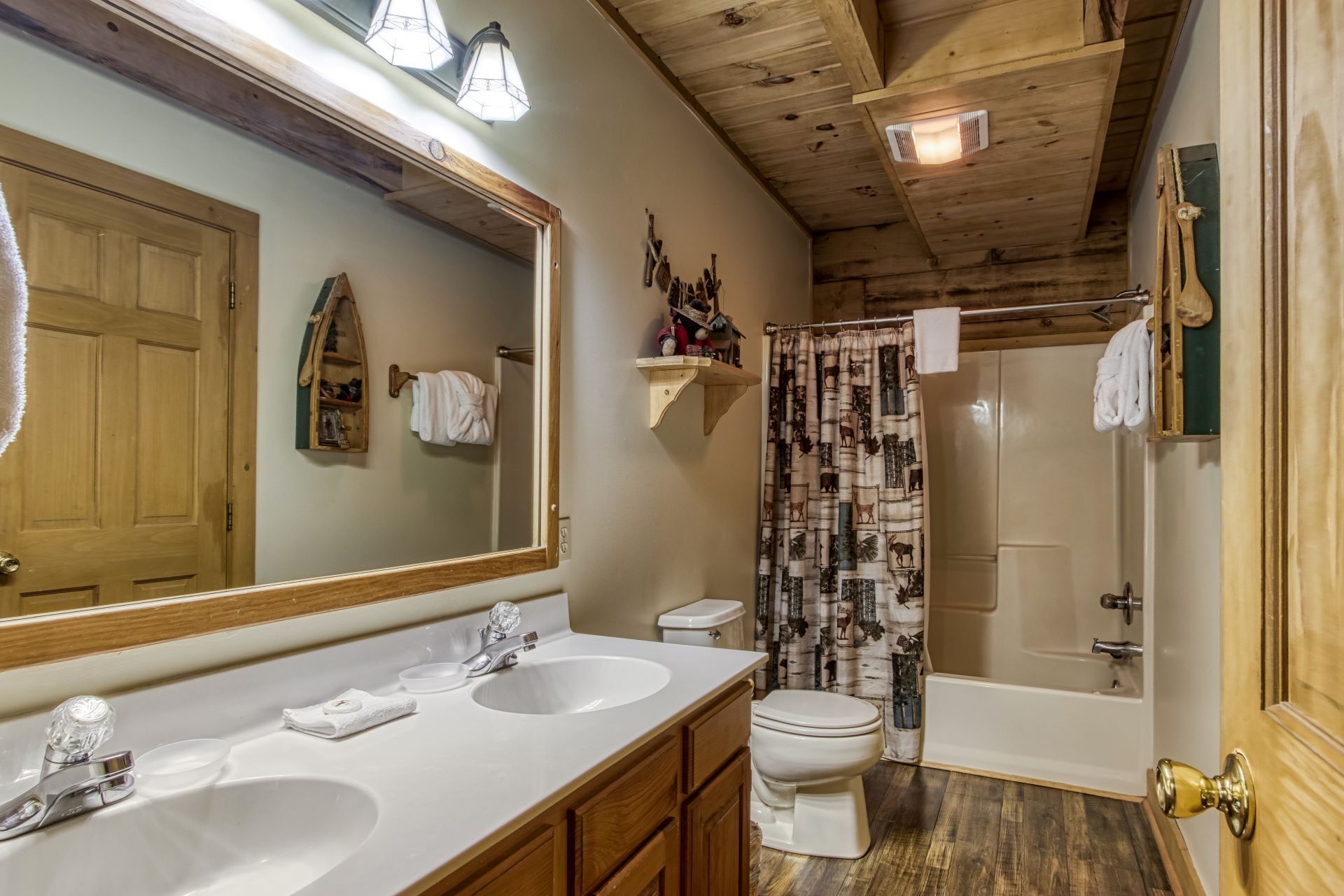 A bathroom with two sinks, a toilet, and a shower.