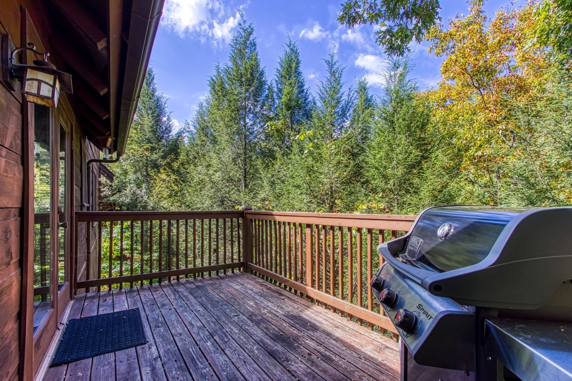 A wooden deck with a barbecue grill.