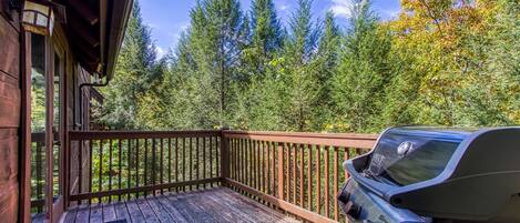 A wooden deck with a barbecue grill.