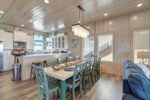 A spacious kitchen with wooden cabinets, a central island, and a dining area with chairs and a table. - Detail and craftsmanship are evident in every space. From the designer kitchen a (Port Aransas)