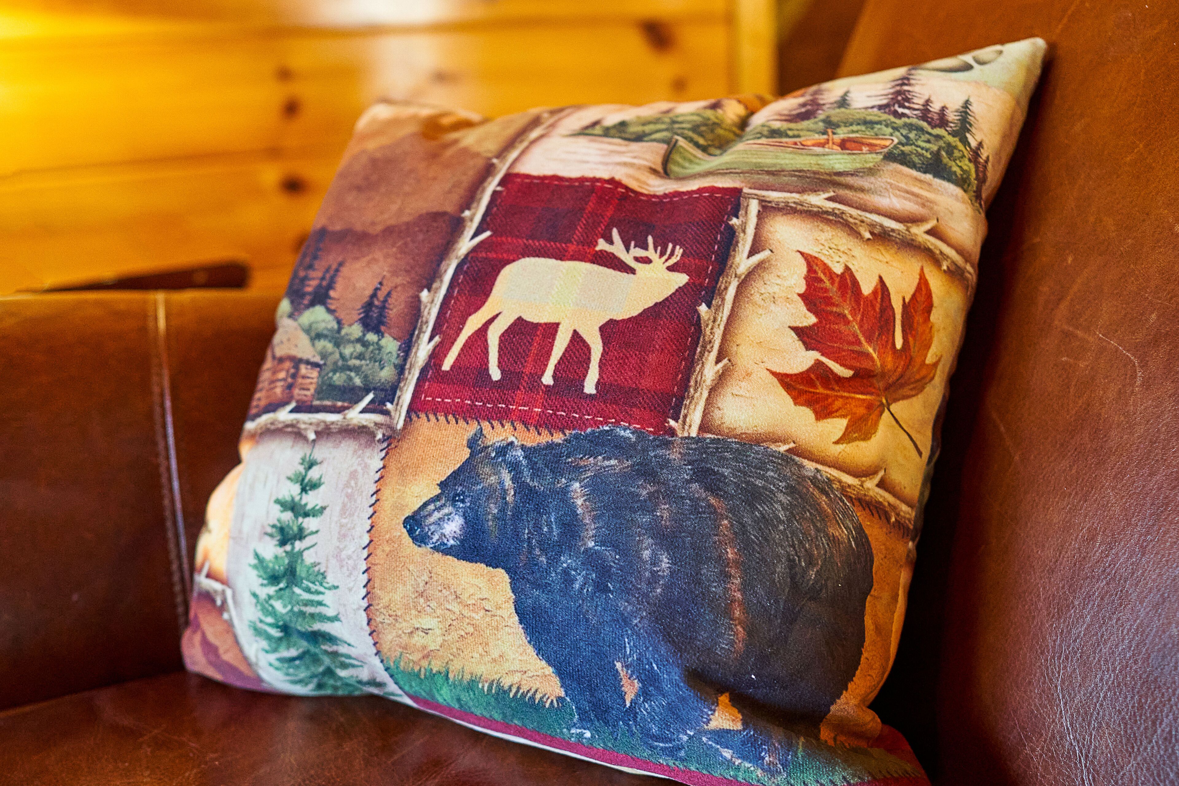 Almohada con diseño patchwork que muestra escenas de fauna y naturaleza.