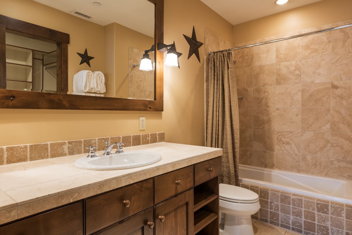 A bathroom with a sink, mirror, star decorations, and a shower curtain.