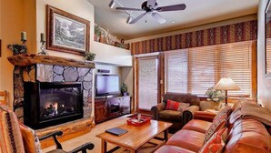 Una sala de estar acogedora con chimenea, televisor y asientos cómodos.