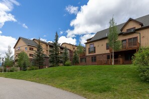 Residents enjoy balconies with outdoor space amidst well-maintained lawns and mature trees.
