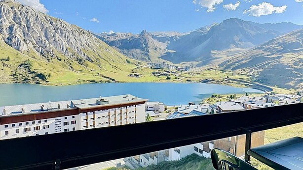 A view from a window overlooking a mountainous landscape with a lake and buildings. - Studio for 4 in Tignes ski-in/ski-out near shops (Tignes)