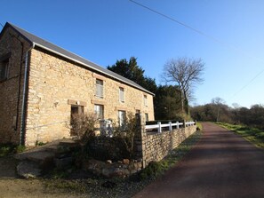 A stone building with a paved driveway.