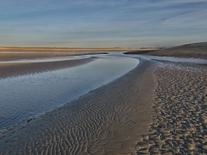 A beach with a curved shoreline and a clear sky.