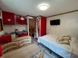 A compact room with a kitchenette, a bed, a television, and a dining area. - Cozy studio in Châtel for 4 people, south-west facing balcony (Châtel)