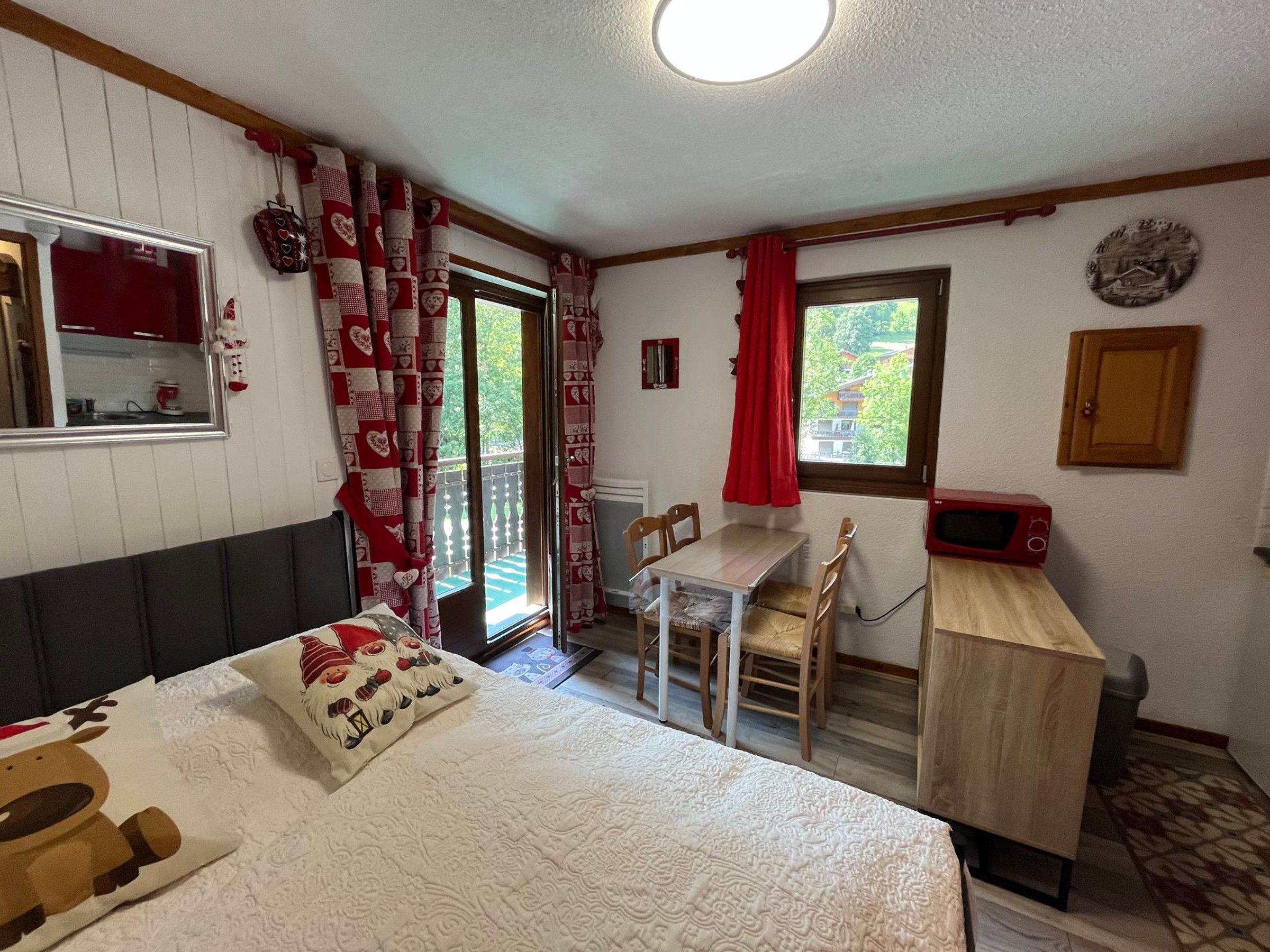 A room with a bed, a desk, a chair, a window, and a microwave.
