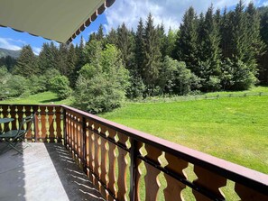 Un balcón con vista a un campo cubierto de césped y árboles.
