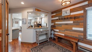 Une cuisine moderne avec un mur d’accent en bois, un banc et un panneau indiquant l’emplacement.
